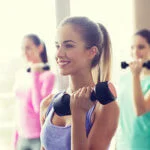 woman holding dumbbell smiling