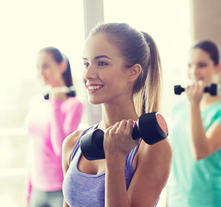 woman holding dumbbell smiling