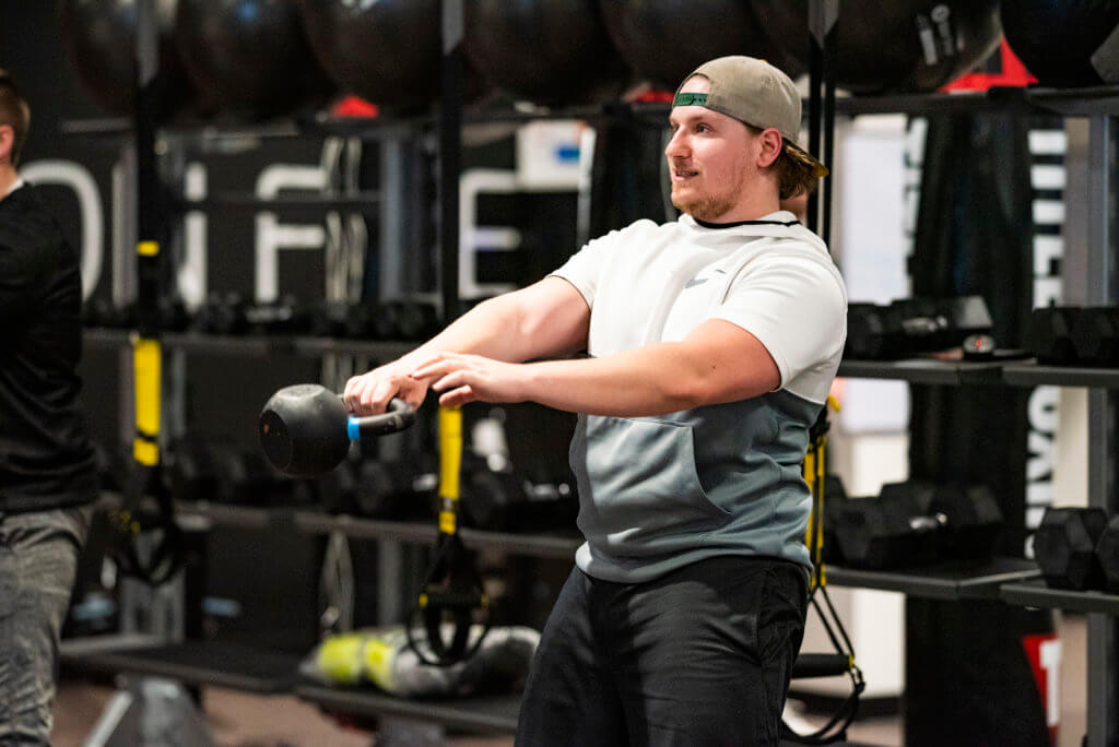 man swinging kettlebell