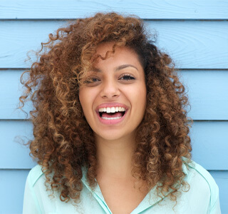 woman smiling in front of blue background