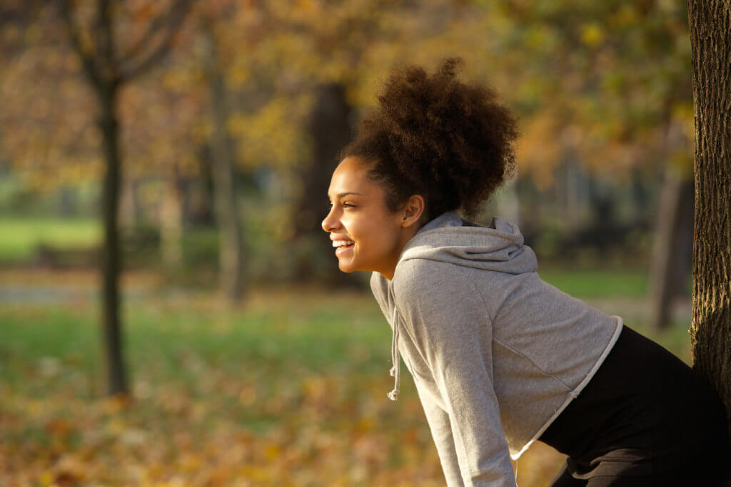 woman bent over smiling after outdoor exercise