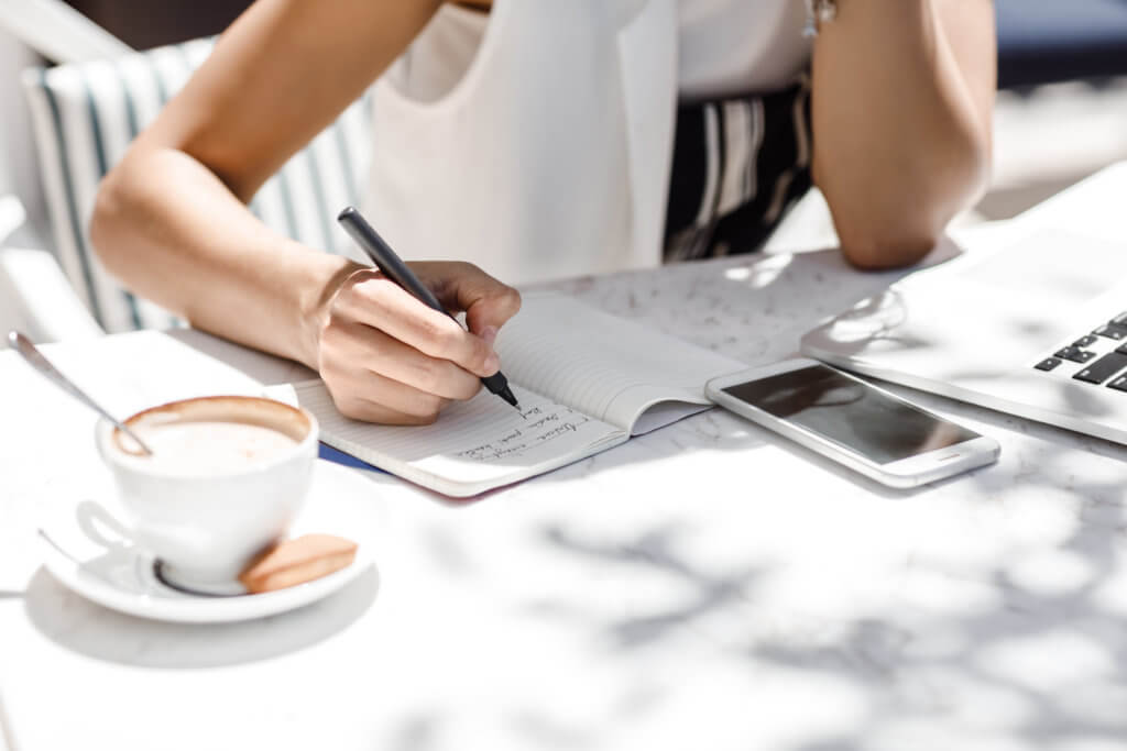 woman taking weight loss notes in a journal