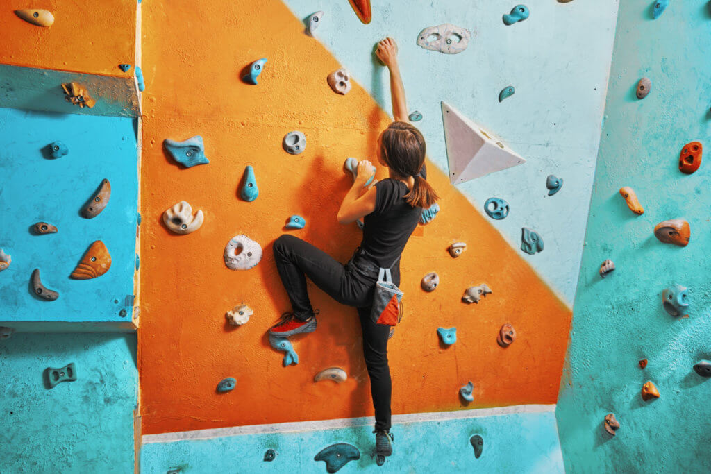 woman rock climbing indoors