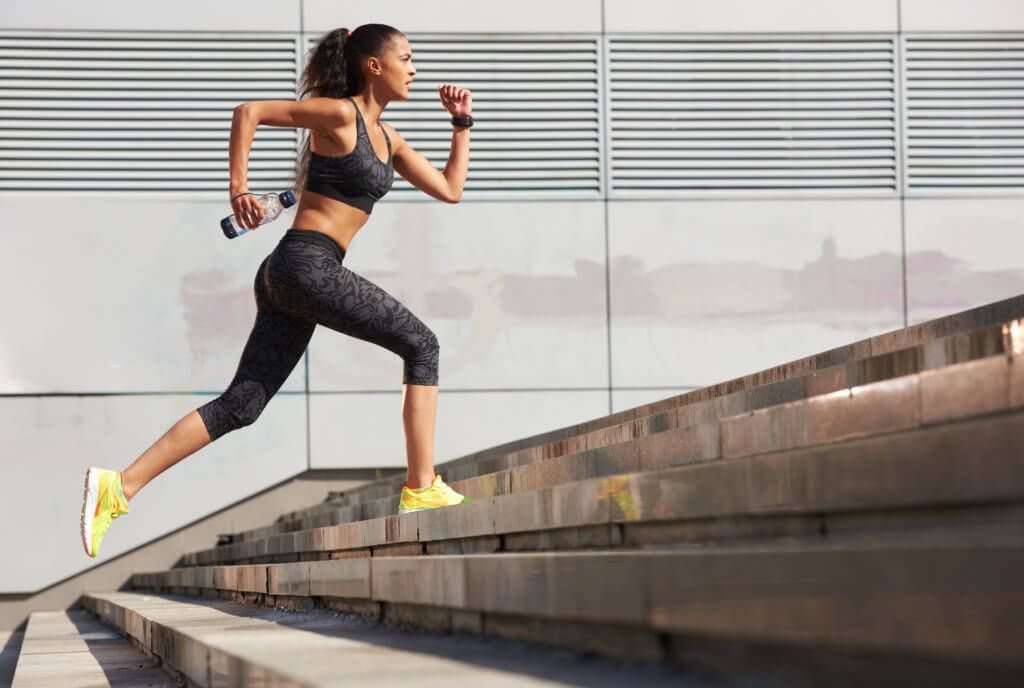 woman running up set of concrete stairs