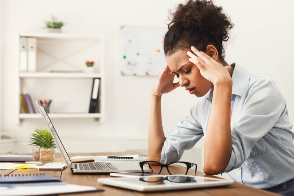 woman sitting in front of computer with headache