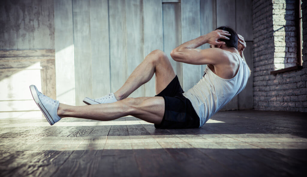 man doing sit ups at the gym