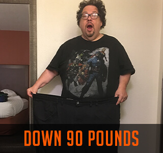 man stands in pants he used to wear before weight loss