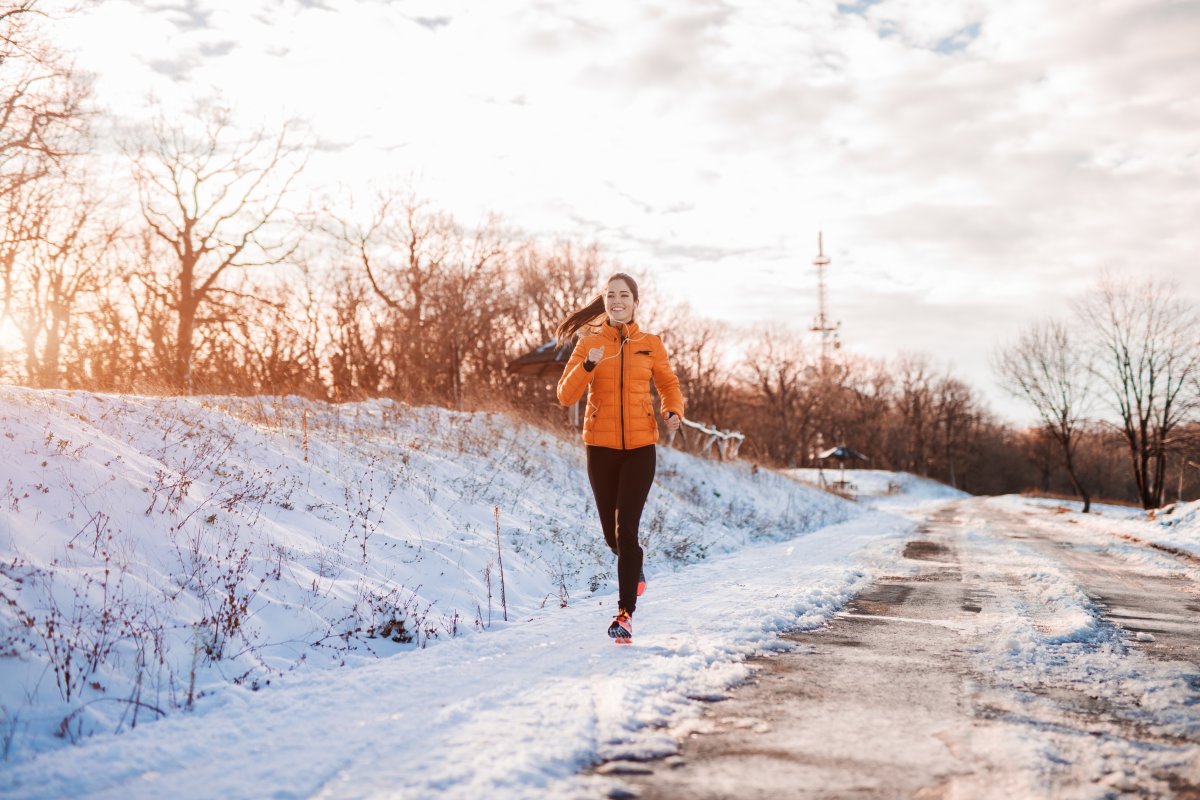 woman in orange running in the cold