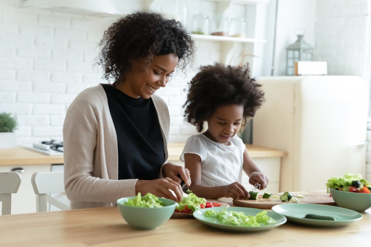 mother and daughter preparing salads at kitchen table